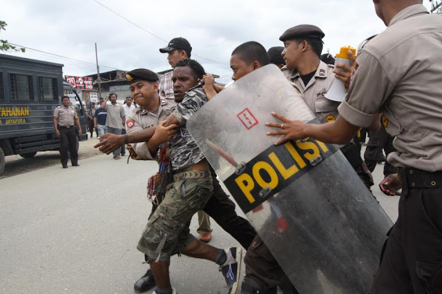 West Papuan activist being arrested by Indonesian riot police